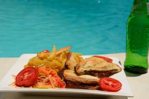 a plate of food with a sandwich and french fries at Kipepeo Lodge Zanzibar in Jambiani