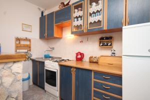 a kitchen with blue cabinets and a white refrigerator at Apartments with parking space Rukavac, Vis - 8836 in Vis