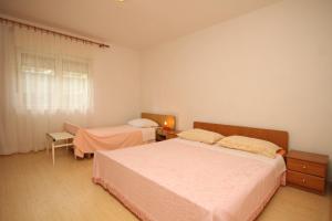 a bedroom with two beds and a window at Apartments with parking space Ugljan - 8479 in Ugljan