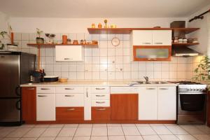 a kitchen with white cabinets and a stainless steel refrigerator at Apartments with parking space Ugljan - 8479 in Ugljan +20 photos
