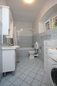uma casa de banho com um lavatório, um WC e uma banheira em Apartments by the sea Sutomiscica, Ugljan - 8474 em Sutomišćica