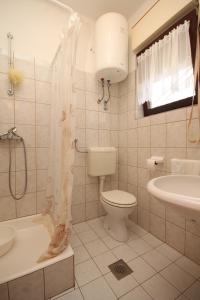 uma casa de banho com um WC, um lavatório e um chuveiro em Apartments with a parking space Ugljan - 8493 em Ugljan