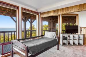 een slaapkamer met een bed en een televisie op een balkon bij Buck Mountain Home 