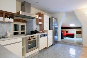 cocina con electrodomésticos blancos y sofá rojo en Apartments with WiFi Split - 8672 en Split
