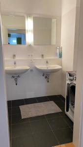 uma casa de banho com 2 lavatórios e uma máquina de lavar roupa em Isabella 4 by SMR Rauris Apartments - inc Spa and National Summercard - near Gondola em Rauris