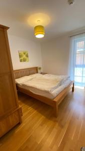 Cama grande en habitación con suelo de madera en Isabella 4 by SMR Rauris Apartments - inc Spa and National Summercard - near Gondola, en Rauris