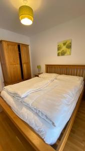 1 cama blanca grande en un dormitorio con luz en Isabella 4 by SMR Rauris Apartments - inc Spa and National Summercard - near Gondola, en Rauris