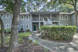 an exterior view of a large house with trees at Coastal Golf Resort Condo Less Than 4 Mi to Beach! in North Myrtle Beach