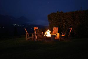 a group of chairs around a fire pit at night at 5TO PISO by Bourbon Hostal in Juayúa
