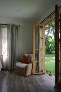 een woonkamer met een stoel en een glazen deur bij 5TO PISO by Bourbon Hostal in Juayúa
