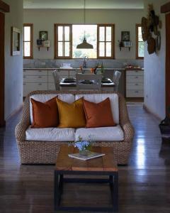 ein Wohnzimmer mit einem Sofa und einer Küche in der Unterkunft 5TO PISO by Bourbon Hostal in Juayúa