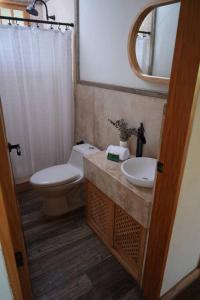 bagno con servizi igienici, lavandino e specchio di 5TO PISO by Bourbon Hostal a Juayúa