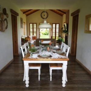 a dining room with a table with chairs and a clock at 5TO PISO by Bourbon Hostal in Juayúa
