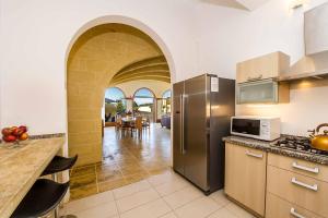 a kitchen with stainless steel appliances and a dining room at Four Winds Holiday Home in Kerċem