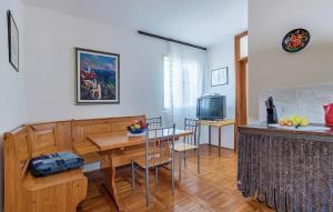 uma cozinha e sala de jantar com uma mesa e uma televisão em Apartment Pjescana Uvala 14564b em Pula