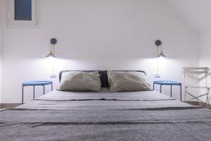 ein Schlafzimmer mit einem Bett mit zwei blauen Tischen in der Unterkunft Suite Gharraf Palermo Old Town in Palermo