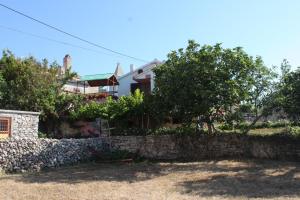 a house with a stone wall and trees at Apartment Stivan 382d in Štivan