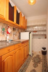 a kitchen with wooden cabinets and a white refrigerator at Apartment Stivan 382d in Štivan