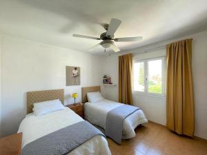 ein Schlafzimmer mit zwei Betten und einem Deckenventilator in der Unterkunft Holiday Home Costa Tropical near Beach in Roquetas de Mar + 32 Fotos