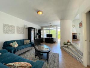 a living room with a blue couch and a glass table at Modern holiday home in Roquetas de Mar with private terrace in Roquetas de Mar