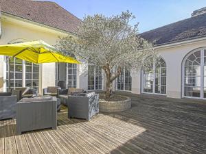 eine Terrasse mit Stühlen, einem Sonnenschirm und einem Baum in der Unterkunft Pleasant holiday home in Aure sur Mer with terrace in Sainte-Honorine-des-Pertes