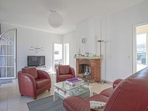 ein Wohnzimmer mit 2 Stühlen und einem Kamin in der Unterkunft Pleasant holiday home in Aure sur Mer with terrace in Sainte-Honorine-des-Pertes