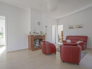 ein Wohnzimmer mit 2 roten Stühlen und einem Kamin in der Unterkunft Pleasant holiday home in Aure sur Mer with terrace in Sainte-Honorine-des-Pertes