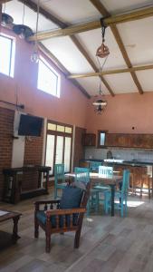 a living room with a table and chairs and a television at Casa de Campo, con Pileta y Asador Criollo!! - "La Ranchada" in Gualeguaychú