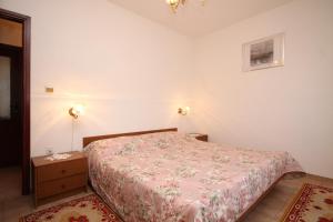 a small bedroom with a bed and a night stand at Apartments by the sea Rukavac, Vis - 2411 in Rukavac
