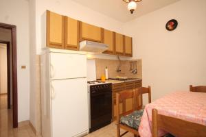 a kitchen with a white refrigerator and a table at Apartments by the sea Rukavac, Vis - 2411 in Rukavac