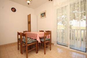 a dining room with a table and chairs and a window at Apartments by the sea Rukavac, Vis - 2411 in Rukavac