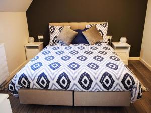 - une chambre avec un lit doté d'une couette bleue et blanche dans l'établissement Fantastic holiday home in Spa with bubble bath and sauna, à Spa