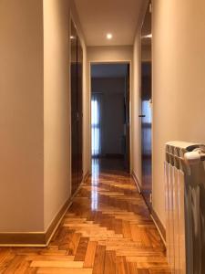 un pasillo con suelo de madera y un pasillo con espejo en Departamento ROMA 3 Ambientes en Bahía Blanca