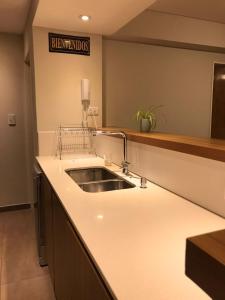 eine Küche mit Spüle und ein Schild an der Wand in der Unterkunft Departamento ROMA 3 Ambientes in Bahía Blanca