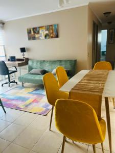 sala de estar con mesa y sillas amarillas en Apart Mejillones - Dpto 24, en Mejillones