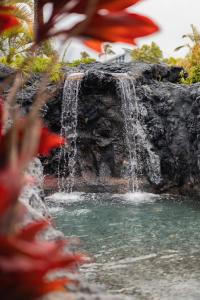 a waterfall in the middle of a garden at The Cliffs at Princeville in Princeville