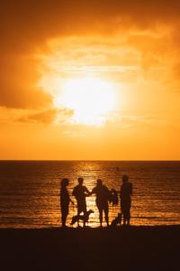 a group of people standing on the beach at sunset at The Cliffs at Princeville in Princeville