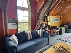 a living room with a blue couch and a window at Cubby House Stay Kaikoura in Kaikoura