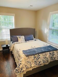 a bed in a bedroom with two windows at Stylish and Cozy Retreat in Buford