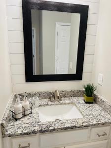 a bathroom sink with a large mirror above it at Stylish and Cozy Retreat in Buford