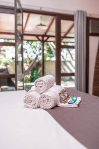 a pile of towels sitting on top of a bed at Pousada Navegantes in Navegantes