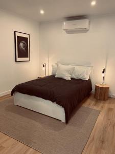 a bedroom with a large bed with a brown blanket at THE DAVEY Luxury home in Nambucca Heads