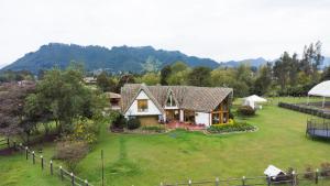 a house on a large yard with a garden at La Isabela Estancia Ecuestre in Tabio