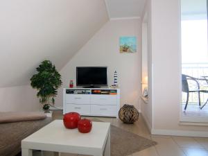 een woonkamer met een tv op een wit dressoir bij holiday home Strandloper, Zinnowitz in Zinnowitz