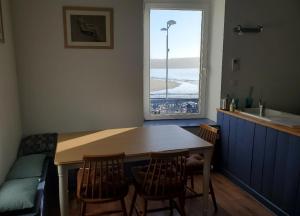 una cucina con tavolo, sedie e finestra di Chez Nany, chaleureux duplex sur le port de Morgat a Crozon