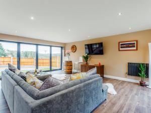 a living room with two couches and a tv at Paddocks View in Breedon on the Hill