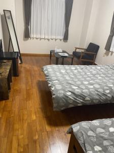 Ie的住宿－ロハス伊江島，客房设有两张床,铺有木地板。
