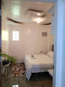 a bedroom with a white bed and a ceiling at CHIEF'S VILLA Rentals Malapascua Island in Malapascua Island