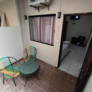 een kamer met 2 stoelen, een tafel en een spiegel bij Lili's Hostel in Santa Cruz de la Sierra