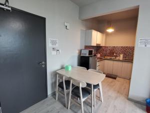 a kitchen with a table and two chairs and a door at Jesselton Quay Citypads in Kota Kinabalu